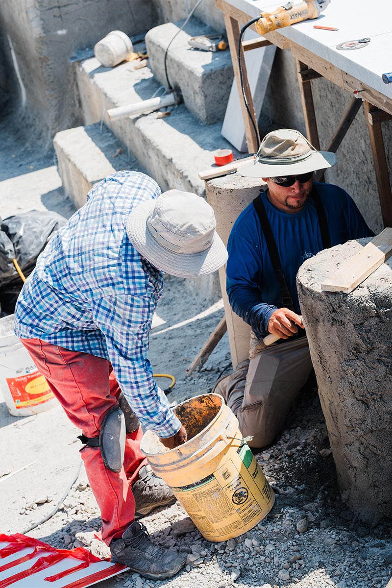 Two workers applying concrete to concrete pools in Cary, North Carolina