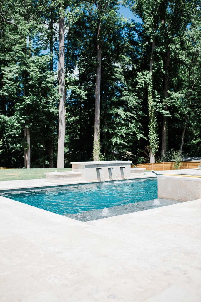 Corner view of Modern Raleigh project with active water feeding water into the pool