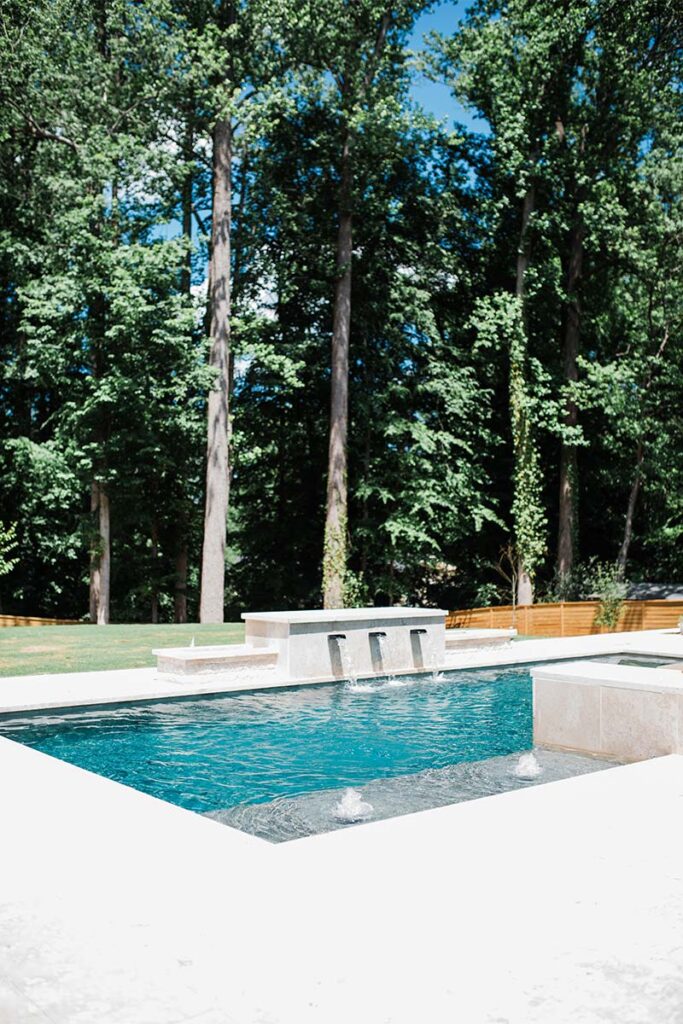 Corner view of Modern Raleigh project with active water feeding water into the pool