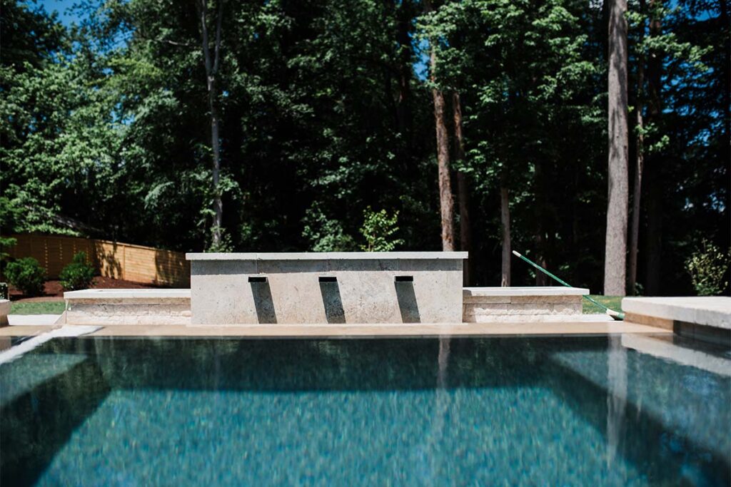 Drone above concrete pool facing pool feeding water
