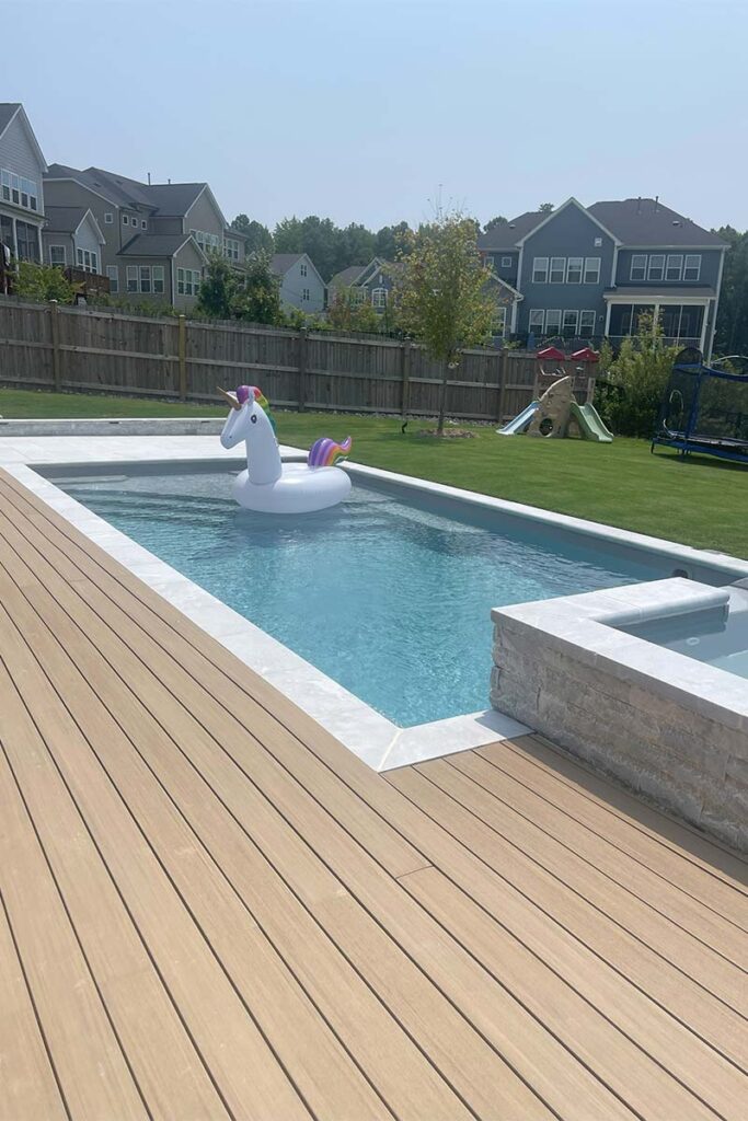 Fiberglass Cary showcases white marble concrete pool with custom pool surround decking