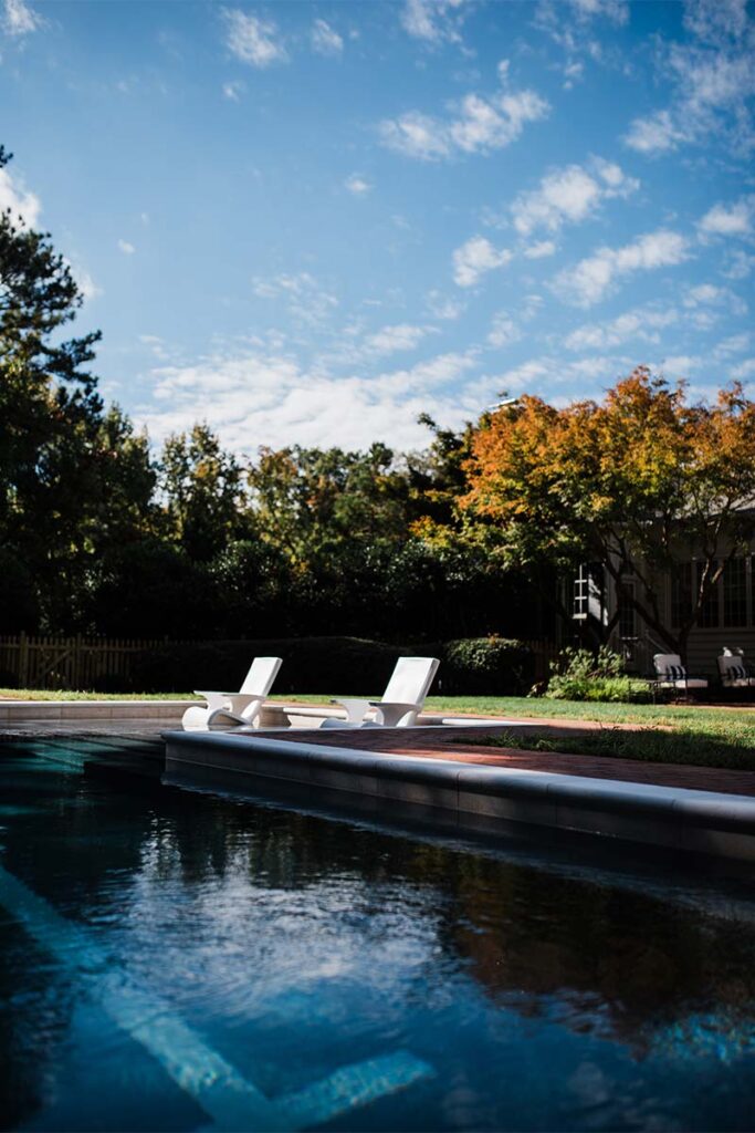 Ground level view of History Chapel Hill Pool with two pool chair in the center