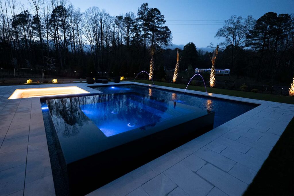 Modern Apex at night showcasing pool lighting, outdoor lighting, and black mirror spa