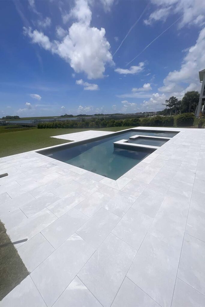 Modern Costal, concrete pool with inset spa with spill over